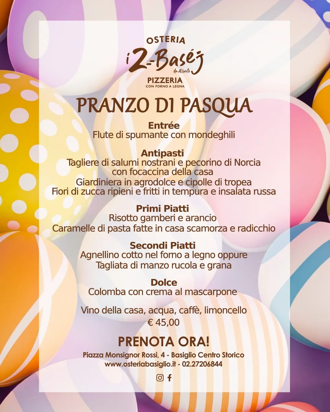 Un volantino digitale festivo e colorato presenta il menù completo del Pranzo di Pasqua presso l'Osteria I 2 Baséj. Lo sfondo è composto da uova di Pasqua pastel e decorate. In alto, il logo dell'Osteria. Il testo descrive dettagliatamente le portate: dall'entrèe di mondeghili, all'antipasto nostrano con focaccina, ai primi di risotto gamberi e arancio e caramelle di pasta, fino ai secondi di agnellino al forno a legna o tagliata di manzo, e al dolce colomba con crema al mascarpone. In basso, la call to action "PRENOTA ORA!" con indirizzo, sito web e numero di telefono di Basiglio